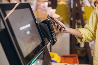 Customer paying contactless with smartphone at a business